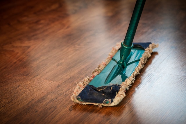 floor-duster being used on dark hardwood flooring